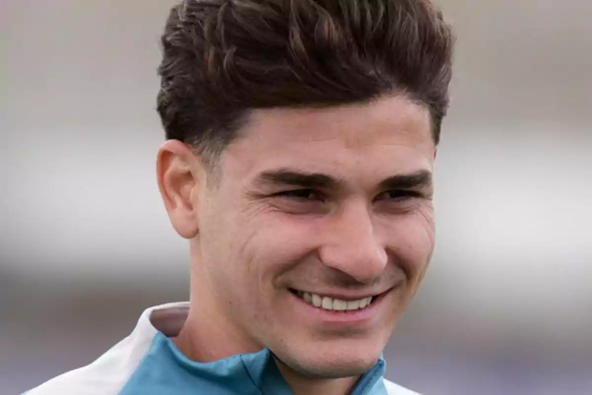 Un hombre joven sonriendo con el cabello oscuro y corto, vistiendo una chaqueta deportiva. Un hombre joven sonriendo con el cabello oscuro y corto, vistiendo una chaqueta deportiva.