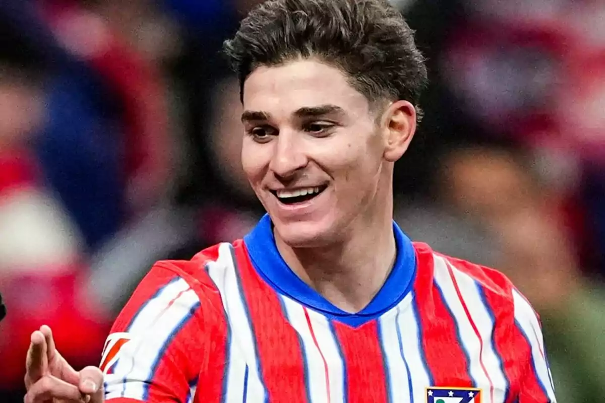 A player smiles while wearing a red and white striped jersey. A player smiles while wearing a red and white striped jersey.