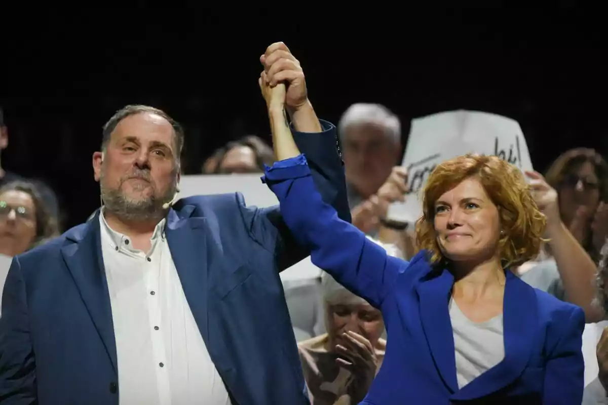 Oriol Junqueras i Elisenda Alamany, donant-se la mà en un míting polític amb gent de fons