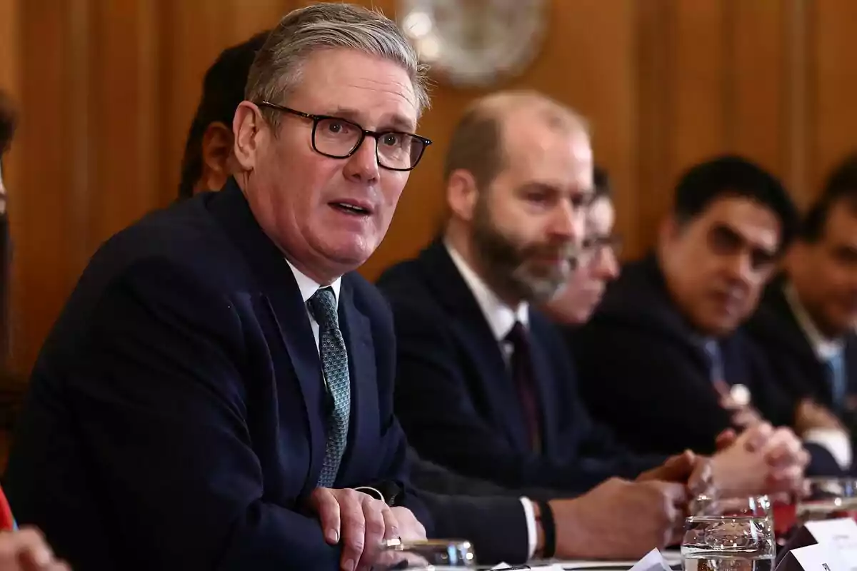 Un grupo de personas en una reunión formal, con un Keir Starmer hablando.