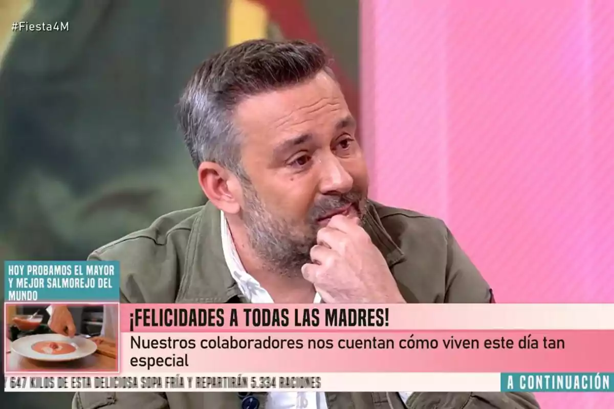 Kike Calleja amb barba i cabell canós apareix a Festa, amb un fons rosa i text en pantalla que felicita les mares i menciona una degustació de salmorejo. Kike Calleja amb barba i cabell canós apareix a Festa, amb un fons rosa i text en pantalla que felicita les mares i menciona una degustació de salmorejo.