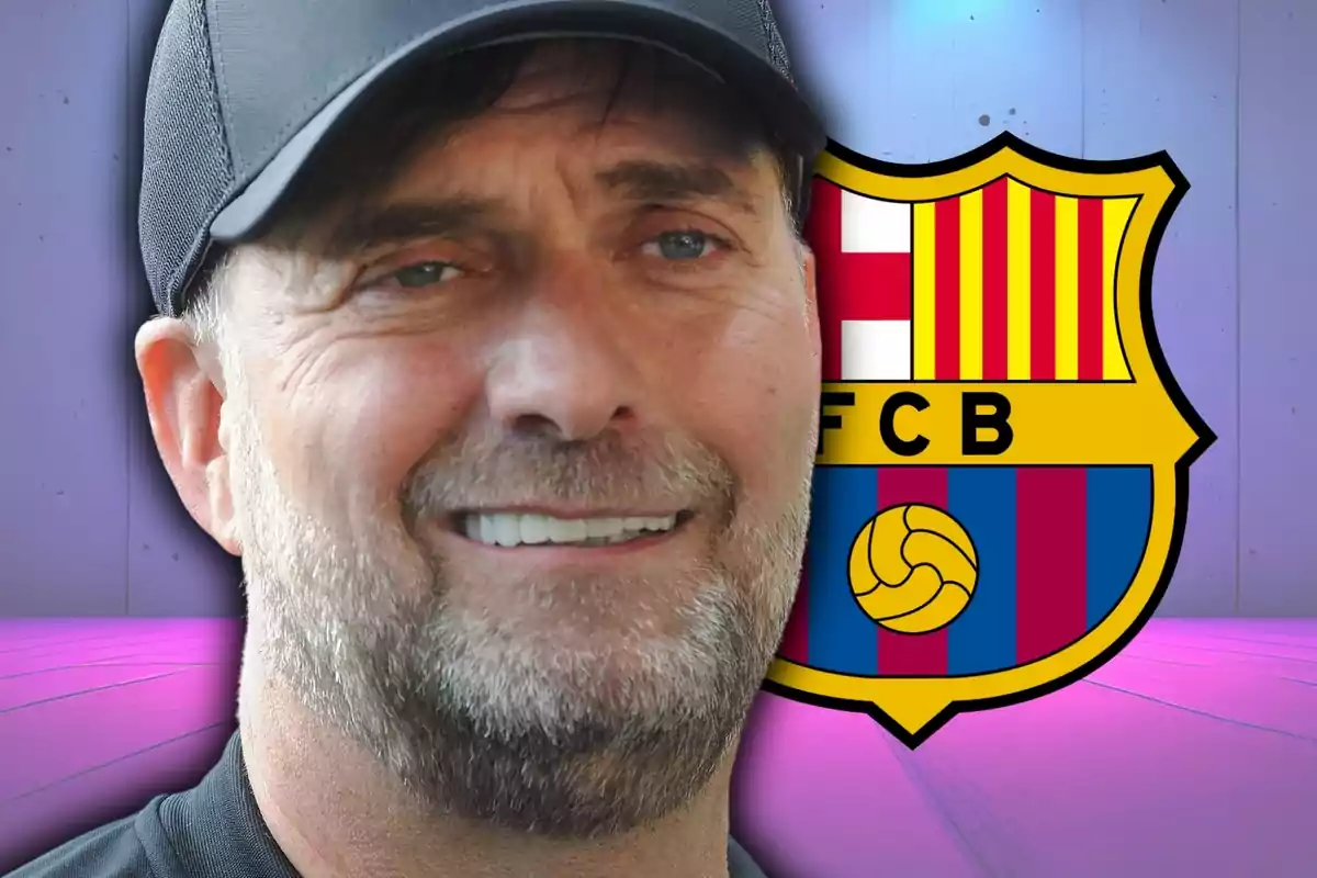 Un home amb gorra negra somriu davant de l'escut del FC Barcelona.