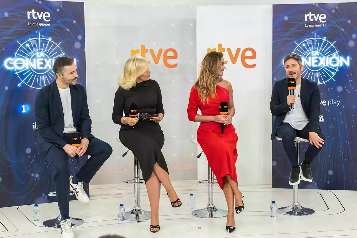 David Gallart, María Eizaguirre, Lara Álvarez i Sergio Calderón asseguts en tamborets participen en una xerrada amb micròfons de rtve en un plató modern amb fons blanc i blau. David Gallart, María Eizaguirre, Lara Álvarez i Sergio Calderón asseguts en tamborets participen en una xerrada amb micròfons de rtve en un plató modern amb fons blanc i blau.