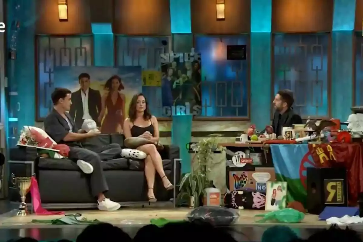 Álex González, Silvia Alonso i David Broncano conversen a 'La Revuelta', decorat amb pòsters, plantes, trofeus i diversos objectes acolorits, mentre una d'elles està asseguda darrere d'un escriptori ple d'articles variats. Álex González, Silvia Alonso i David Broncano conversen a 'La Revuelta', decorat amb pòsters, plantes, trofeus i diversos objectes acolorits, mentre una d'elles està asseguda darrere d'un escriptori ple d'articles variats.