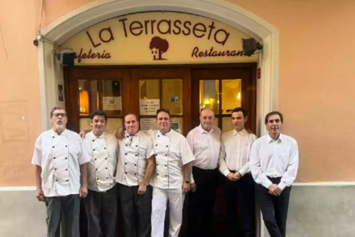 Un grupo de personas posando frente a la entrada de un restaurante llamado "La Terrasseta".