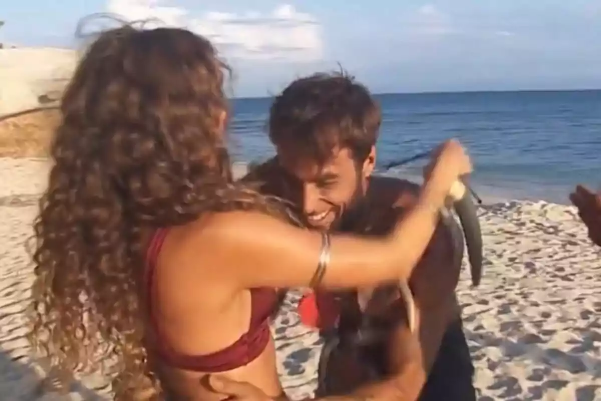 Laura Madrueño i Montoya somrients s'abracen a la platja mentre l'home sosté un peix a Supervivientes.