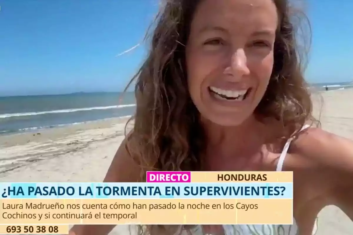 Laura Madrueño somrient a la platja amb el mar de fons, amb un text en pantalla que pregunta sobre l'estat d'una tempesta en un programa de televisió a Hondures.