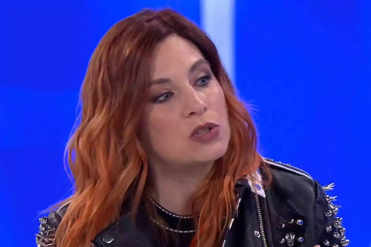 Leire Martínez amb cabell pèl-roig i jaqueta de cuir negre en un fons blau a Hi ha una cosa que et vull dir.