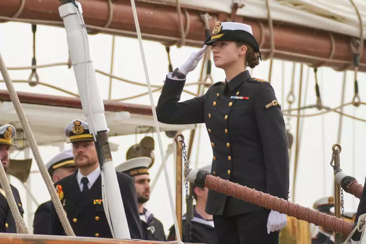 Leonor saluda en la cubierta de un barco mientras otros marineros observan. Leonor saluda en la cubierta de un barco mientras otros marineros observan.