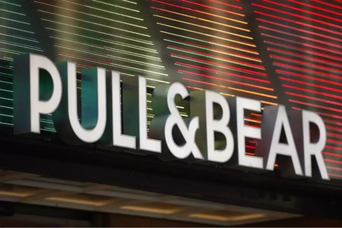 Rètol de la marca de roba Pull&Bear amb llums de colors de fons a l'exterior d'una de les botigues