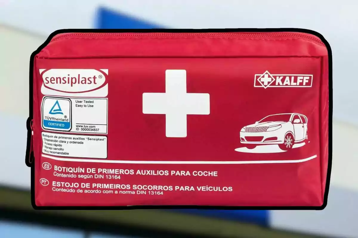 Farmaciola de primers auxilis vermella per a cotxe amb una creu blanca i un dibuix d’un automòbil a la part frontal Farmaciola de primers auxilis vermella per a cotxe amb una creu blanca i un dibuix d’un automòbil a la part frontal