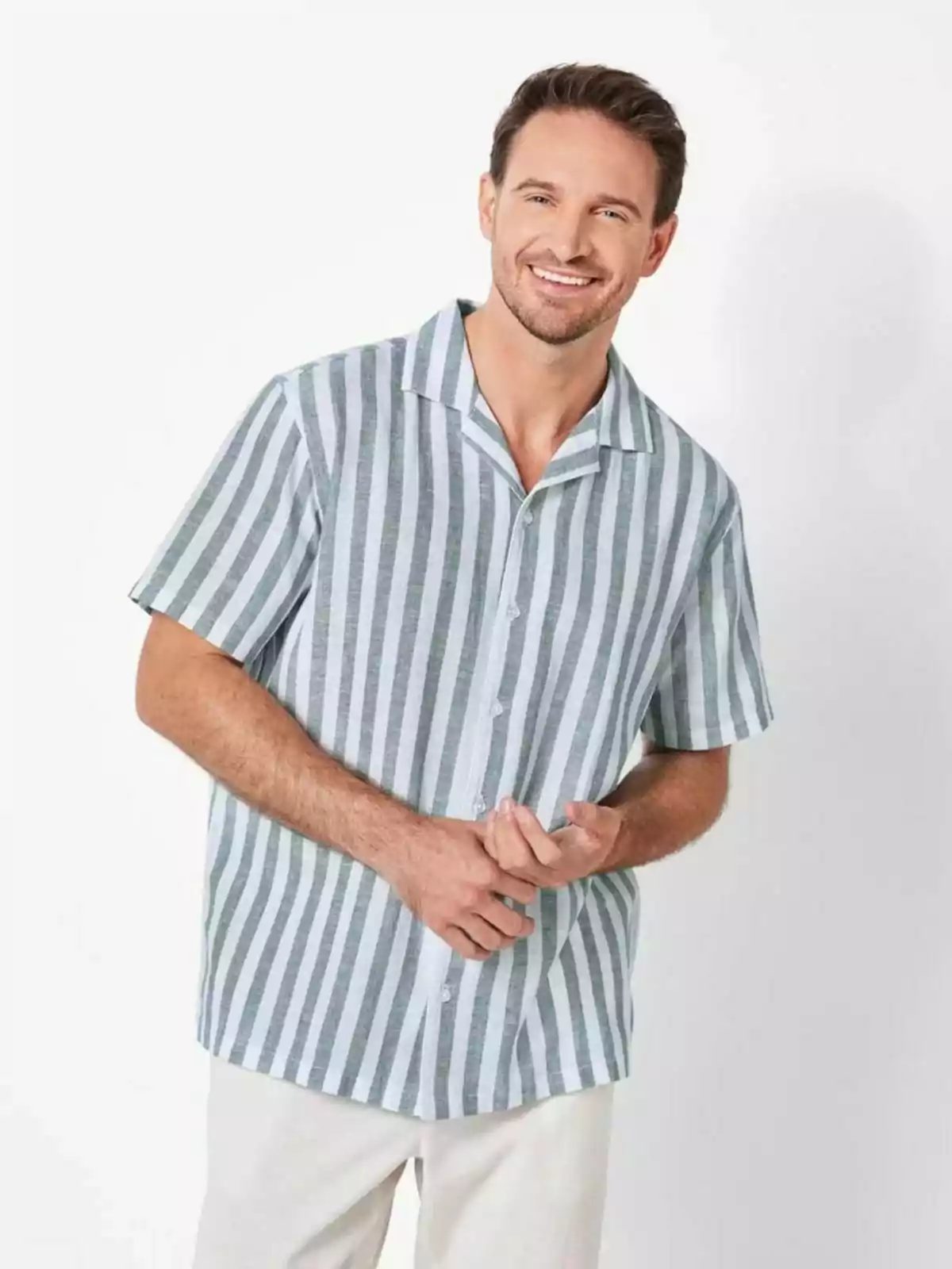 Home somrient amb camisa de ratlles verticals i pantalons clars. Home somrient amb camisa de ratlles verticals i pantalons clars.