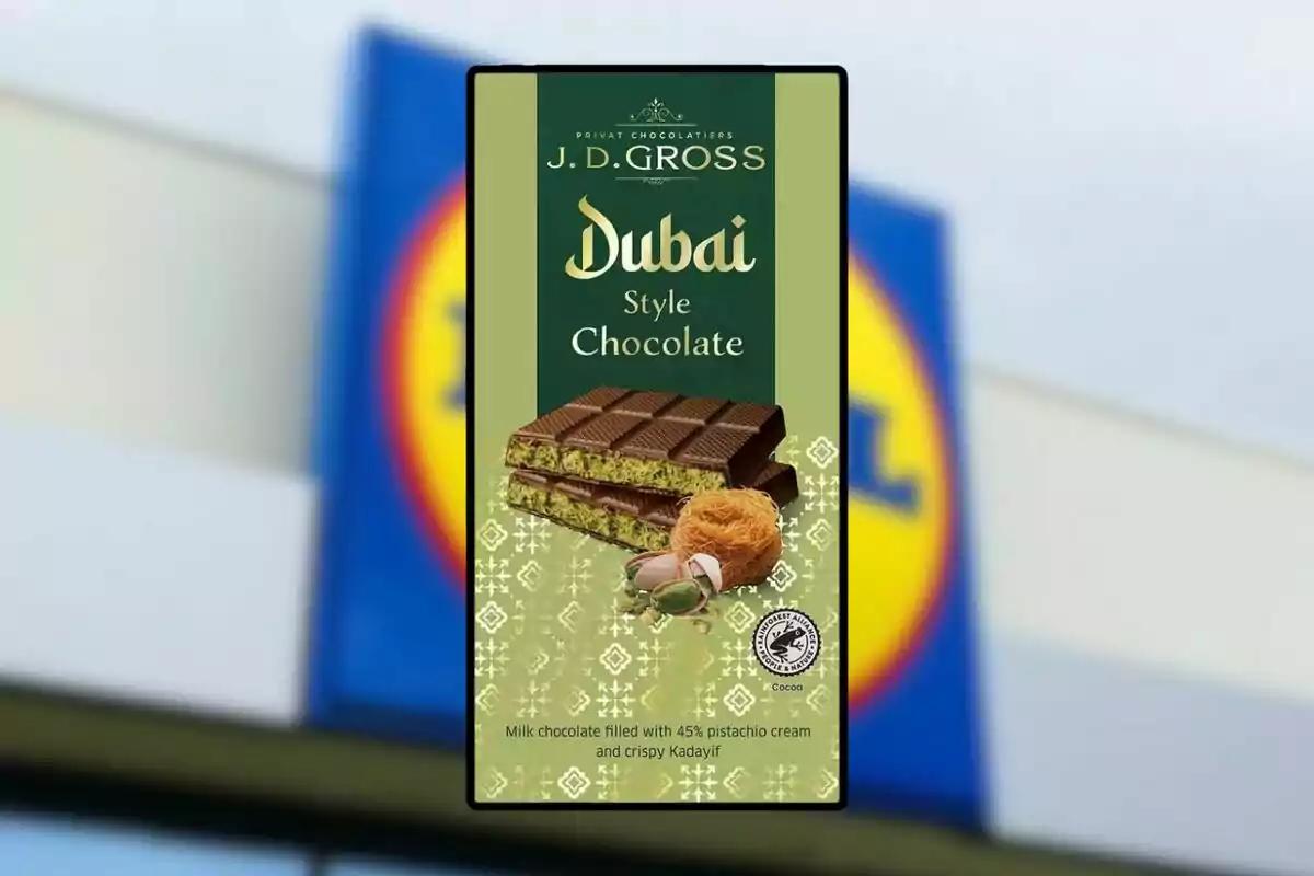 Embalatge de xocolata estil Dubai de J.D. Gross amb farciment de crema de festuc i kadayif cruixent, amb un fons desenfocat d'un logotip de supermercat. Embalatge de xocolata estil Dubai de J.D. Gross amb farciment de crema de festuc i kadayif cruixent, amb un fons desenfocat d'un logotip de supermercat.