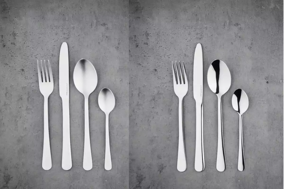 Two sets of stainless steel cutlery on a gray surface.