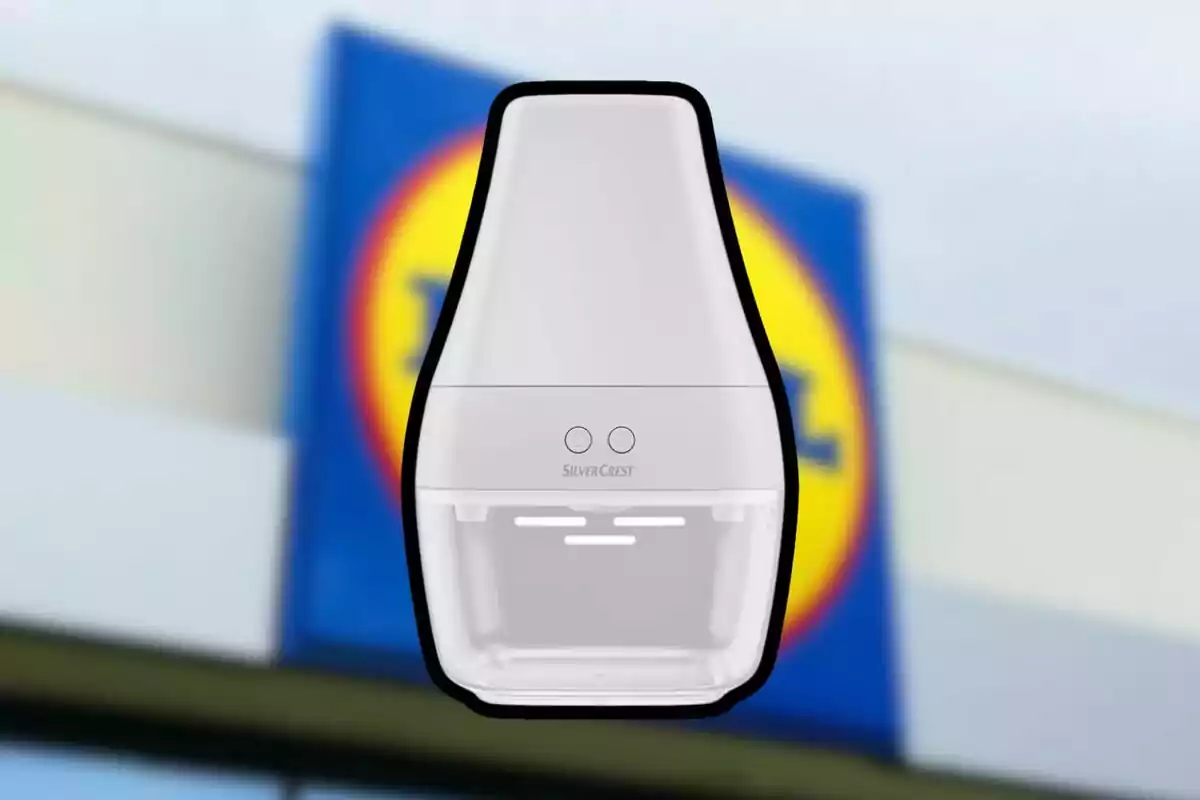 A white device from the brand SilverCrest with a blurred background of a blue and yellow sign. A white device from the brand SilverCrest with a blurred background of a blue and yellow sign.