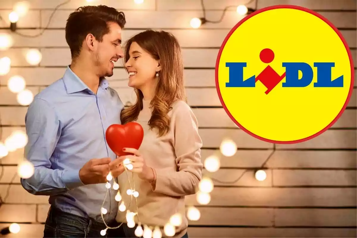 Una pareja sonriente sostiene un corazón rojo rodeado de luces con el logo de Lidl en el fondo.