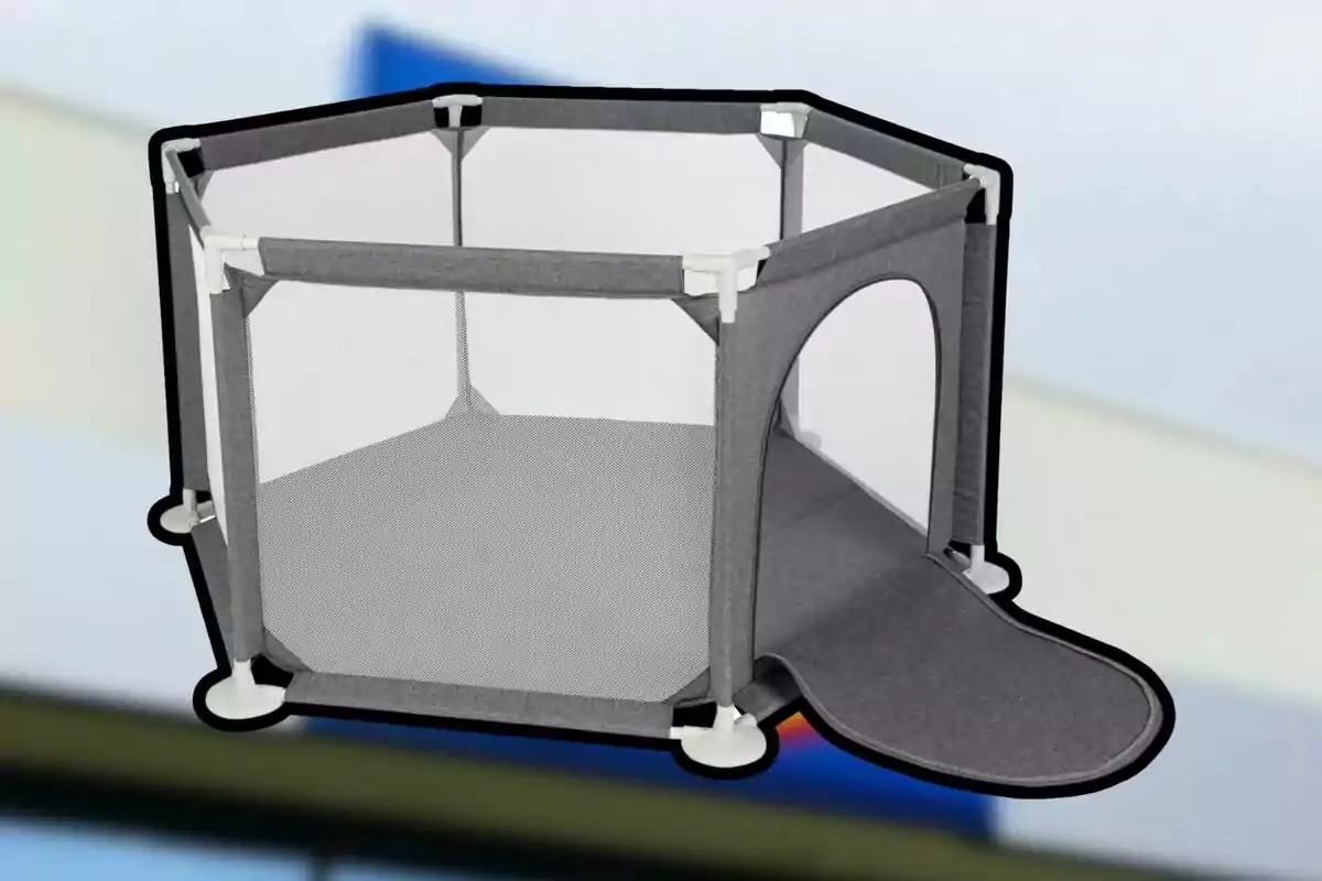 Un corralito hexagonal gris con malla y una puerta abierta en un fondo desenfocado. Un corralito hexagonal gris con malla y una puerta abierta en un fondo desenfocado.
