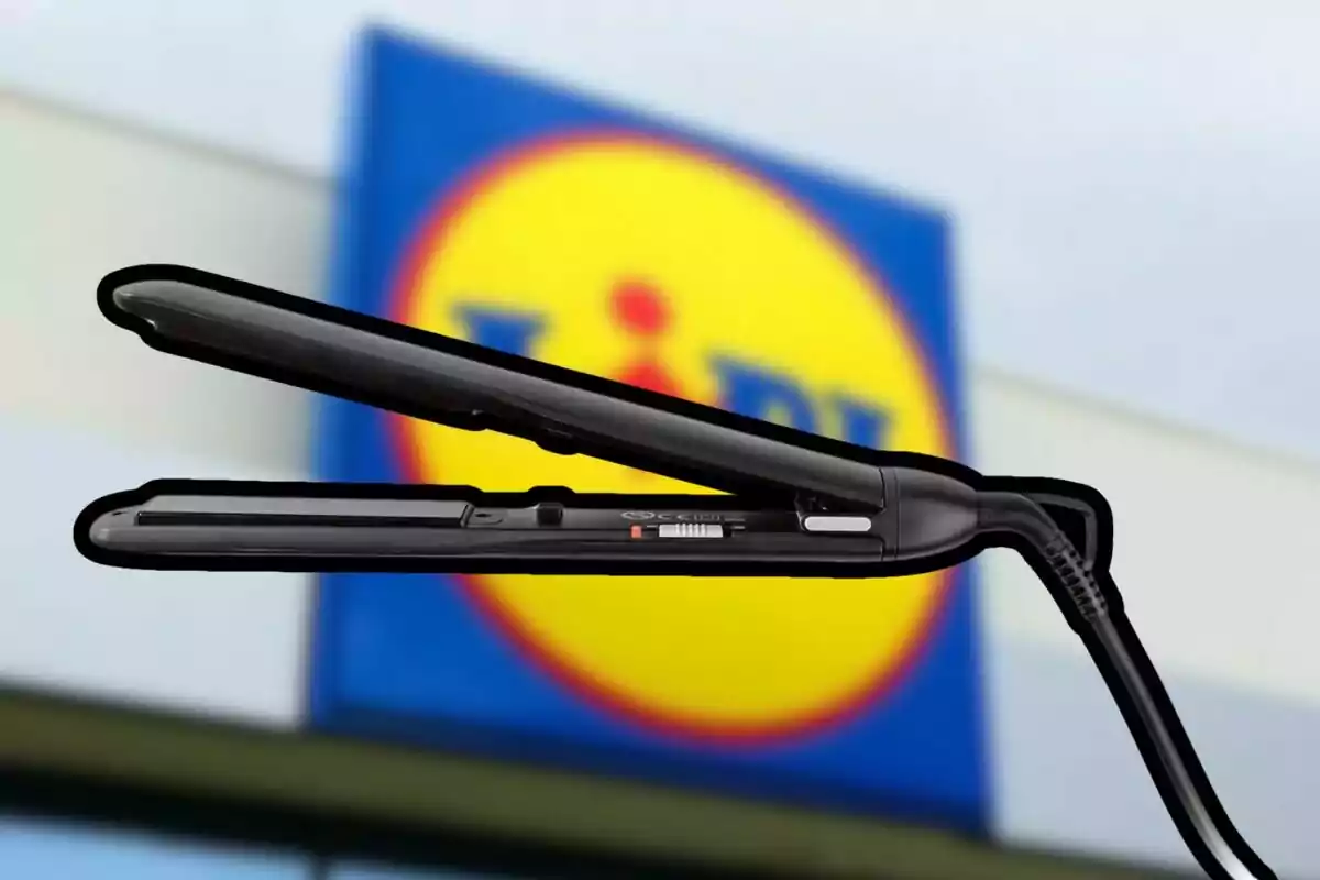 A black hair straightener in front of a blurry store sign.