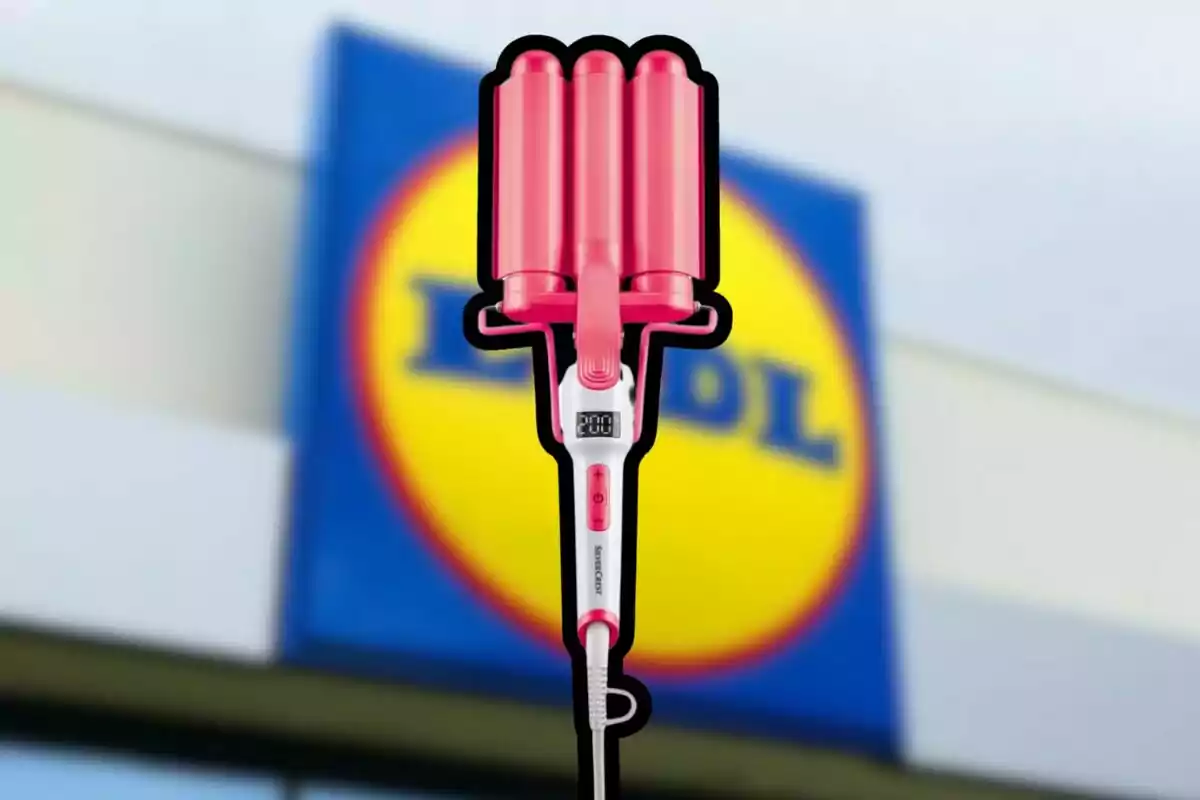 Arrissador de cabells rosa amb pantalla digital en primer pla davant d’un rètol borros de la botiga Lidl Arrissador de cabells rosa amb pantalla digital en primer pla davant d’un rètol borros de la botiga Lidl