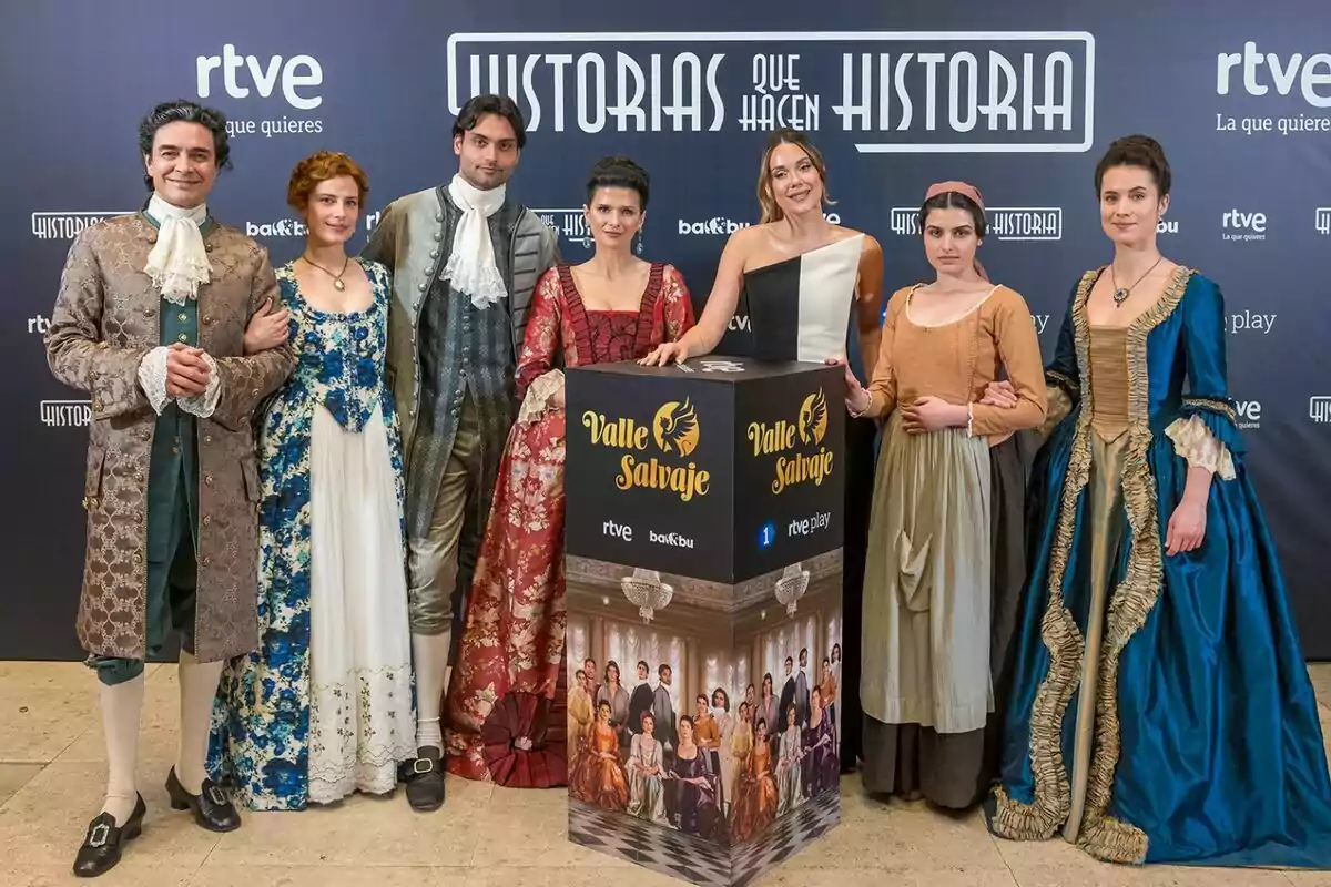 Un grup de persones vestides format per José Manuel Seda, Rocio Suárez de Puga, Sabela Arán, Marco Pernas, Loren Mairena i Miren Arrieta amb vestits d'època al costat de Lorena Gómez posen davant d'un fons promocional de Un grup de persones vestides format per José Manuel Seda, Rocio Suárez de Puga, Sabela Arán, Marco Pernas, Loren Mairena i Miren Arrieta amb vestits d'època al costat de Lorena Gómez posen davant d'un fons promocional de