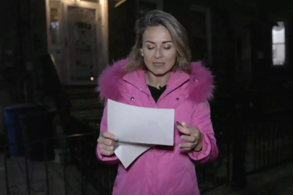 Mamen Salas amb un abric rosa sosté un full de paper mentre està dreta davant d’una casa de nit a ‘Cuarto Milenio’. Mamen Salas amb un abric rosa sosté un full de paper mentre està dreta davant d’una casa de nit a ‘Cuarto Milenio’.