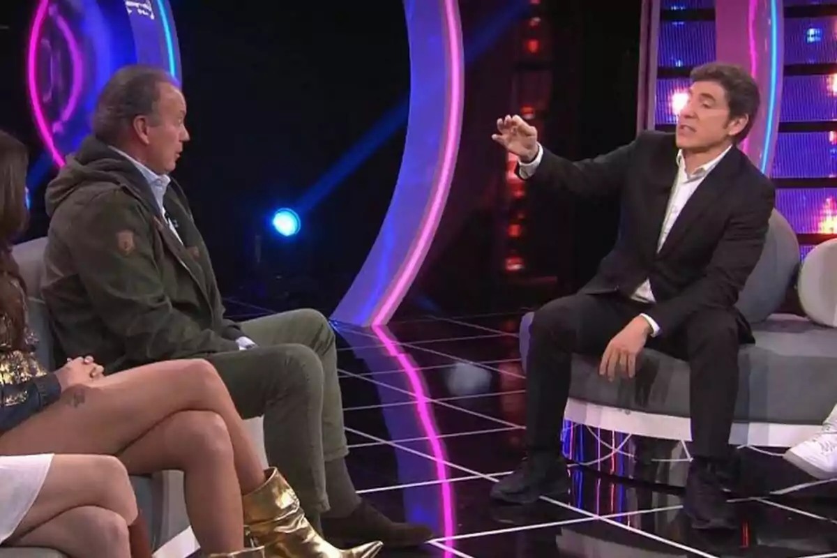 Bertín Osborne juntament amb Manel Fuentes està assegut a Tu Cara Me Suena il·luminat amb llums de colors, mentre un home amb vestit gesticula durant una conversa. Bertín Osborne juntament amb Manel Fuentes està assegut a Tu Cara Me Suena il·luminat amb llums de colors, mentre un home amb vestit gesticula durant una conversa.