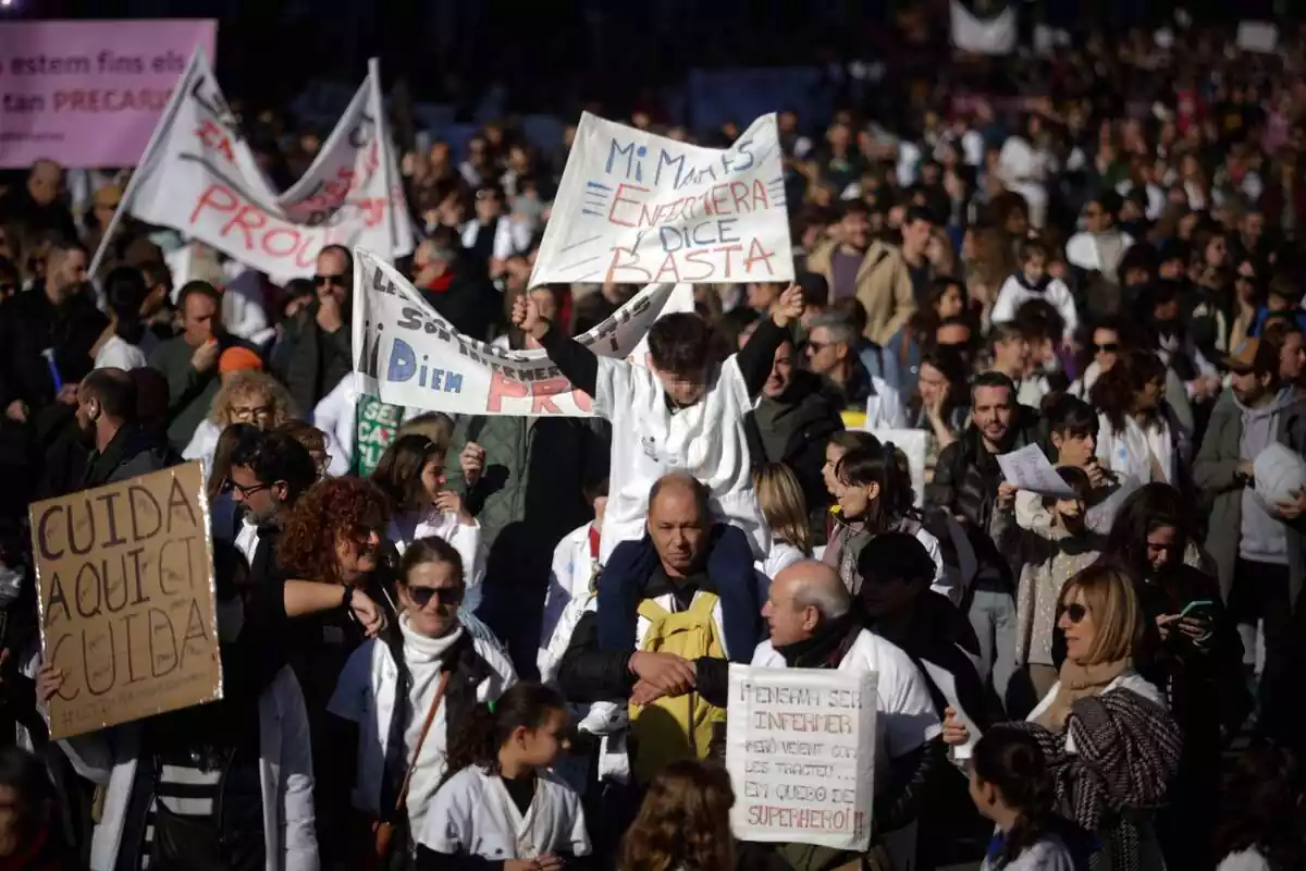 Pla general de la manifestació d'infermeres a Barcelona, amb desenes de persones amb pancartes reincidicatives