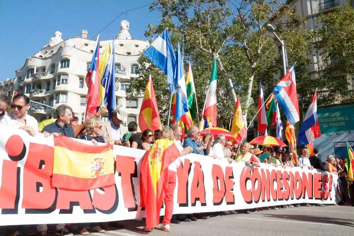 Inici de la manifestació del 12 d'octubre a Barcelona amb diverses persones subjectant una pancarta amb el lema "prou ja de concessions" i onejant diverses banderes d'Espanya, Hondures, Paraguai, Xile i Mèxic