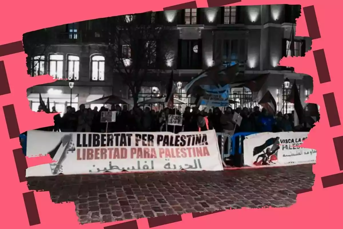 Una manifestació nocturna al carrer amb pancartes que expressen suport a Palestina, envoltada d?un marc vermell.