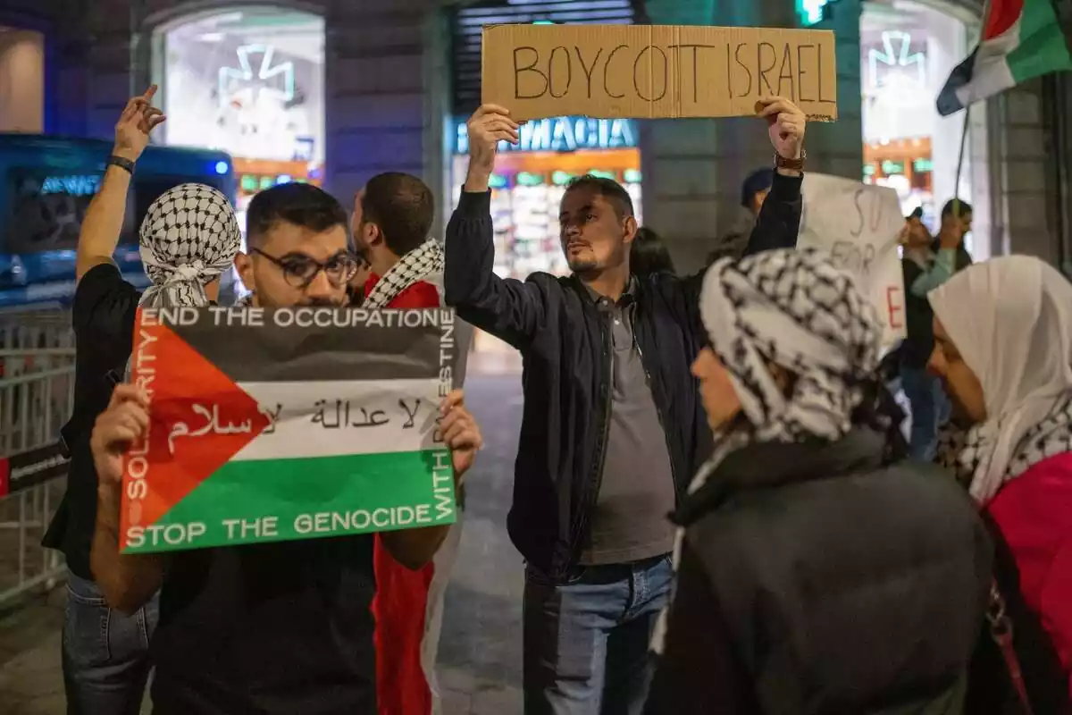 Diverses persones es manifesten contra Israel amb cartells de 'Boicot Israel' o 'Stop Genocidi'