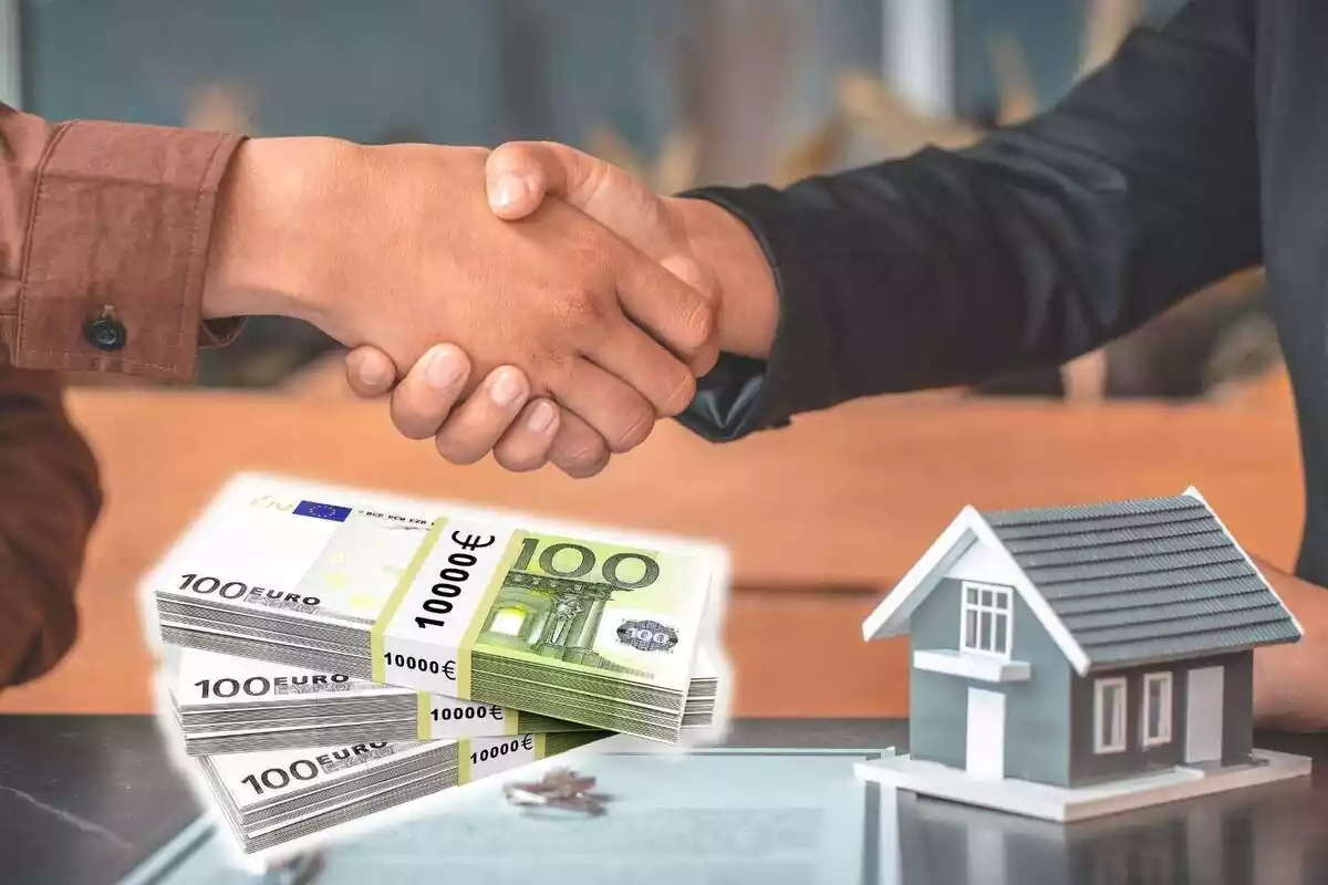Dues persones donant-se la mà després de signar un contracte al costat de la figura d'una casa i bitllets d'euros