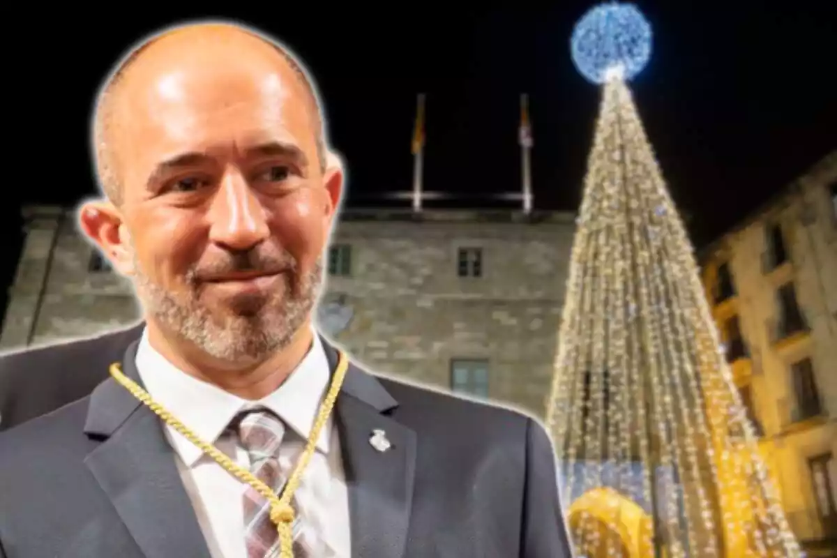 Plànol curt mitjà de Marc Aloy, alcalde de Manresa, amb una imatge d'un arbre de Nadal encès a una plaça de la ciutat