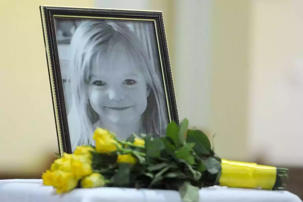 Un marc de fotos amb una imatge de Madeleine McCann amb unes flors grogues al davant