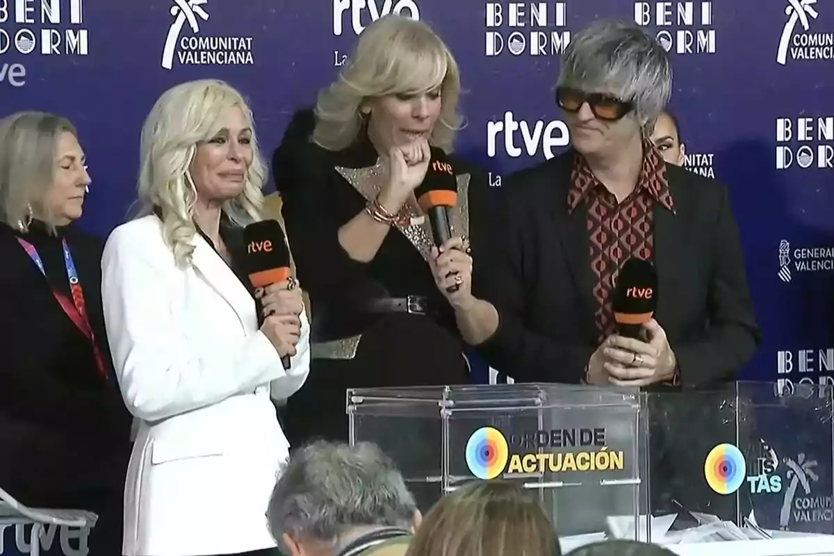 Un grup de persones sostenint micròfons en un esdeveniment amb fons blau que té logotips de RTVE i Benidorm.