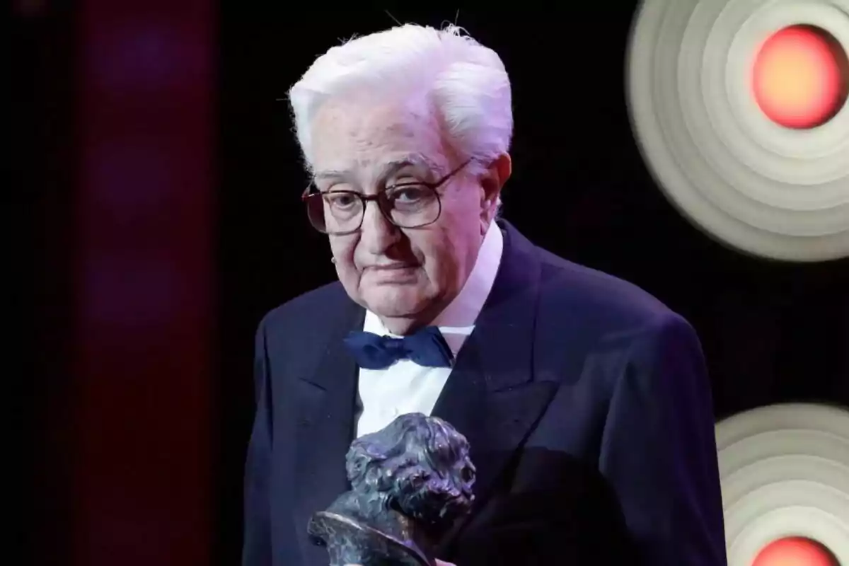 Maríano Ozores gran amb ulleres i cabell blanc sosté un trofeu en un esdeveniment formal. Maríano Ozores gran amb ulleres i cabell blanc sosté un trofeu en un esdeveniment formal.