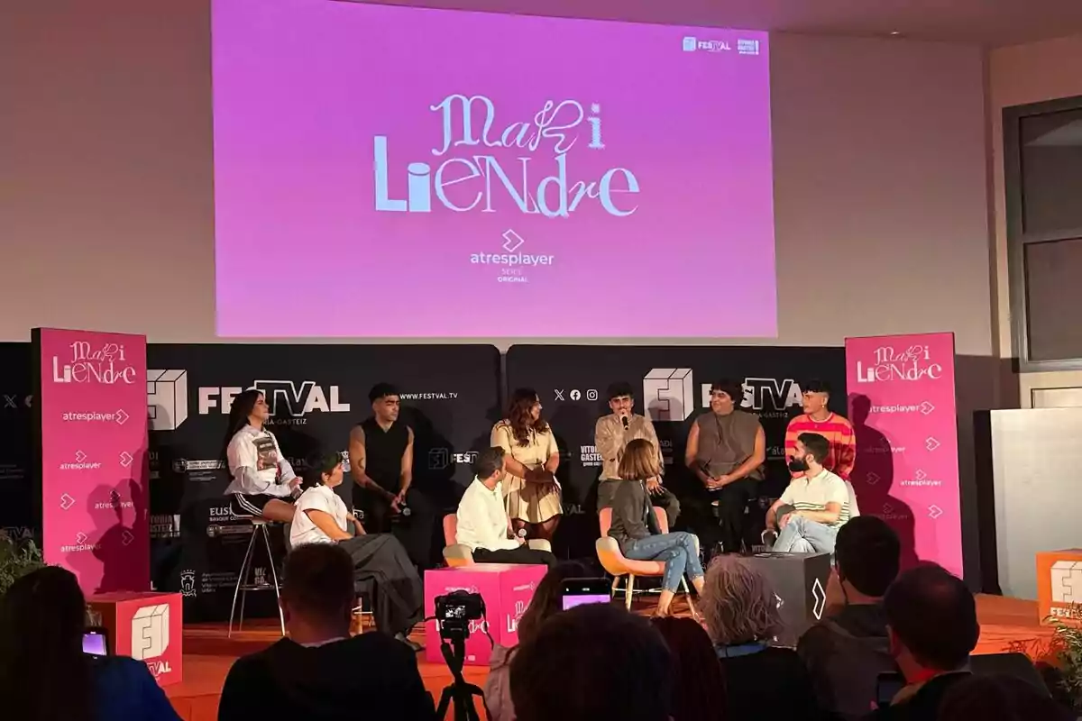 Un grup de persones com Montse García, Emilio Sánchez Zaballos, Martin Urrutia, Omar Ayuso, Blanca Martínez, Ienesi o Carlos González està assegut en un escenari participant en un panell de discussió, amb un cartell rosa de "Mariliendre" i "atresplayer" a el fons.