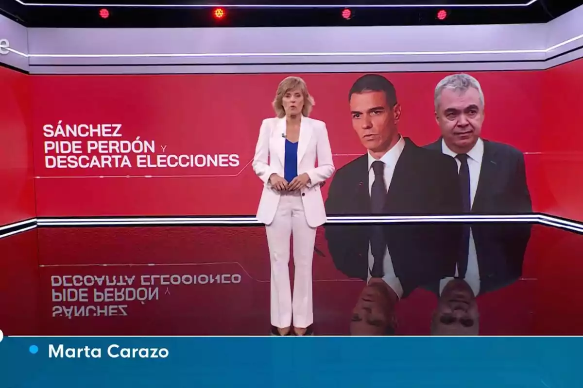 Presentadora d'informatius dreta, Marta Carazo, en un estudi de televisió amb fons vermell i dos homes en pantalla al costat del text Sánchez demana perdó i descarta eleccions Presentadora d'informatius dreta, Marta Carazo, en un estudi de televisió amb fons vermell i dos homes en pantalla al costat del text Sánchez demana perdó i descarta eleccions