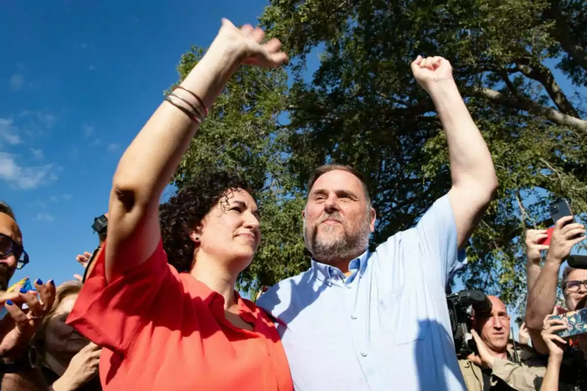 Marta Rovira i Oriol Junqueras aixecant els braços en un esdeveniment exterior.