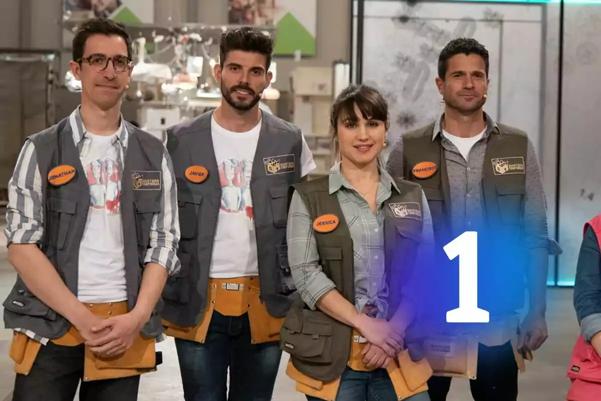Quatre persones amb armilles i eines posen juntes en un taller de Masters de la Reforma, totes porten plaques amb els seus noms i hi ha el logo de La 1 gran al centre de la imatge.