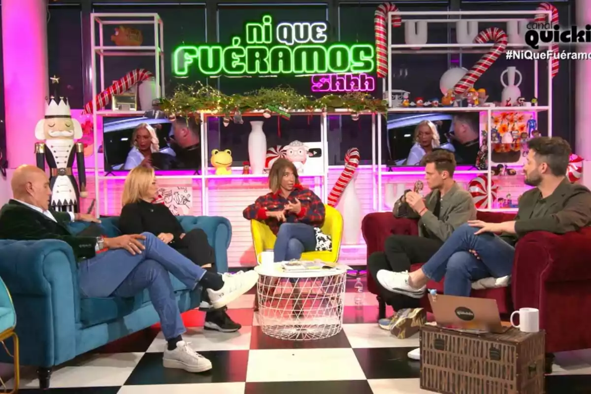 Kiko Matamoros, Belén Esteban, María Patiño, Gonzalo Vázquez i Javi de Hoyos estan asseguts en un set de televisió colorit amb decoració nadalenca i un rètol que diu "Ni que fuéramos shhh".