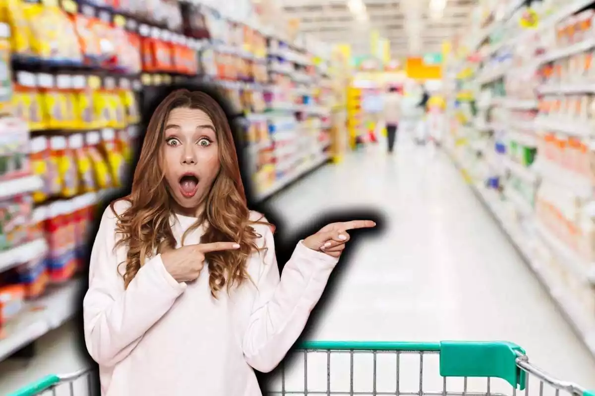 Dona rossa, jersei clar, sorpresa assenyalant amb les dues mans cap a la seva esquerra, sobre fons de supermercat desenfocat