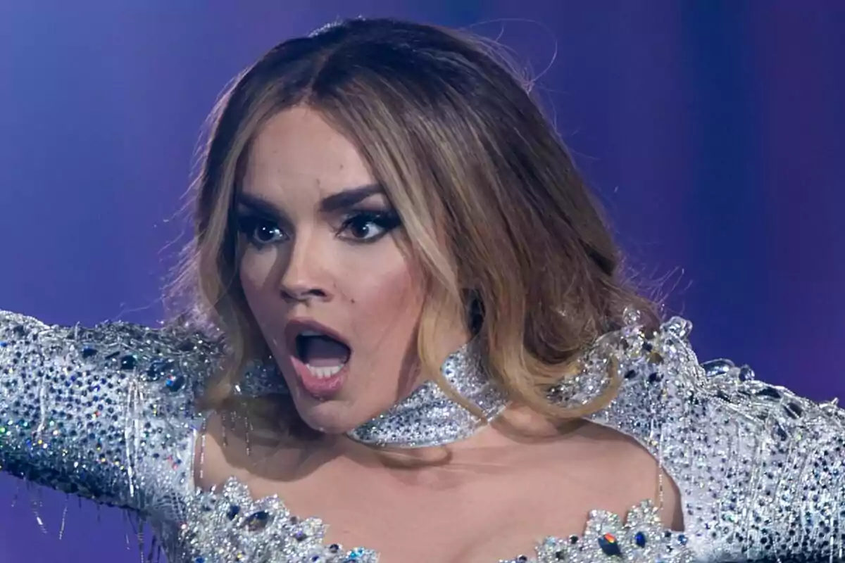 Melody amb expressió de sorpresa a l'escenari d'Eurovisió, vestida amb un vestit brillant i decorat amb pedreria.