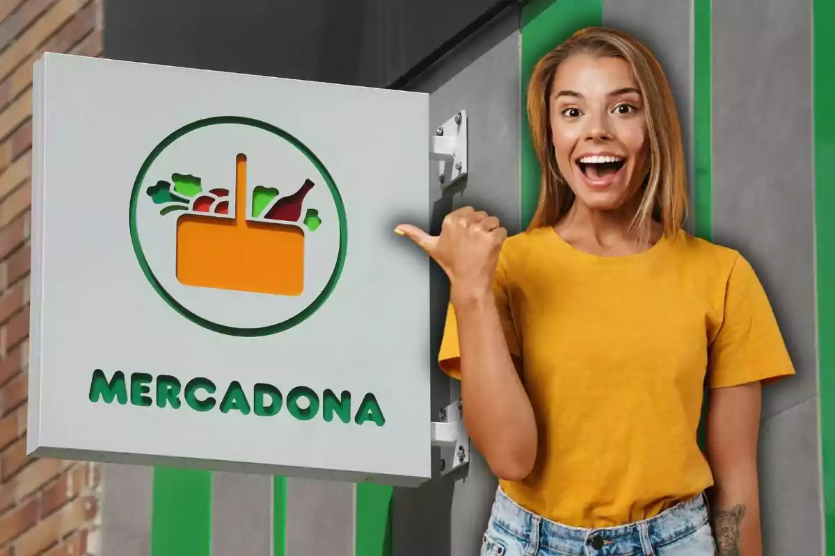 Una persona sonriente con camiseta amarilla señala un cartel de Mercadona que tiene un logo de cesta de compras.