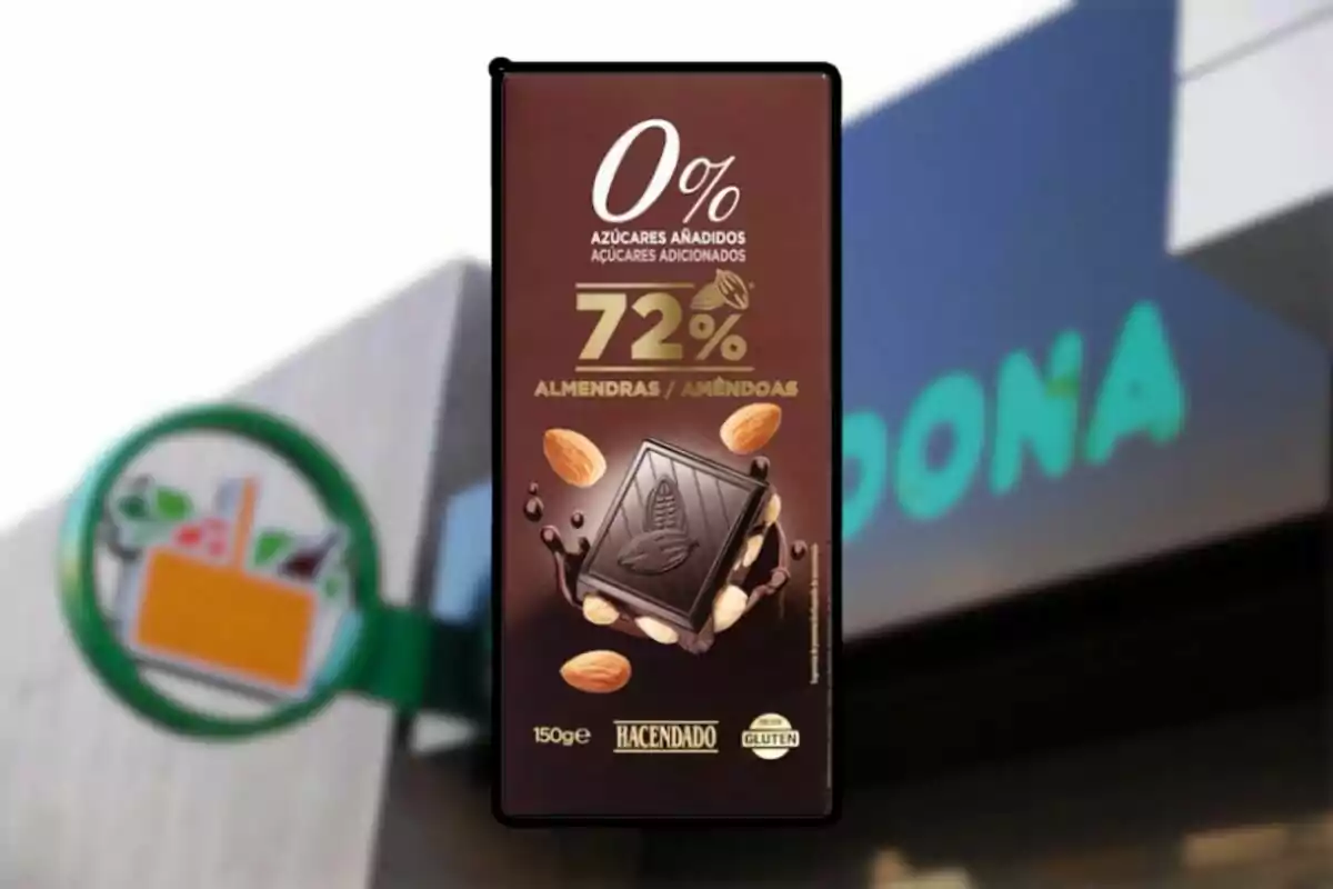 Un paquet de xocolata negra amb ametlles de la marca Hacendado, amb un 72% de cacau i sense sucres afegits, davant d'un fons borros d'un supermercat. Un paquet de xocolata negra amb ametlles de la marca Hacendado, amb un 72% de cacau i sense sucres afegits, davant d'un fons borros d'un supermercat.