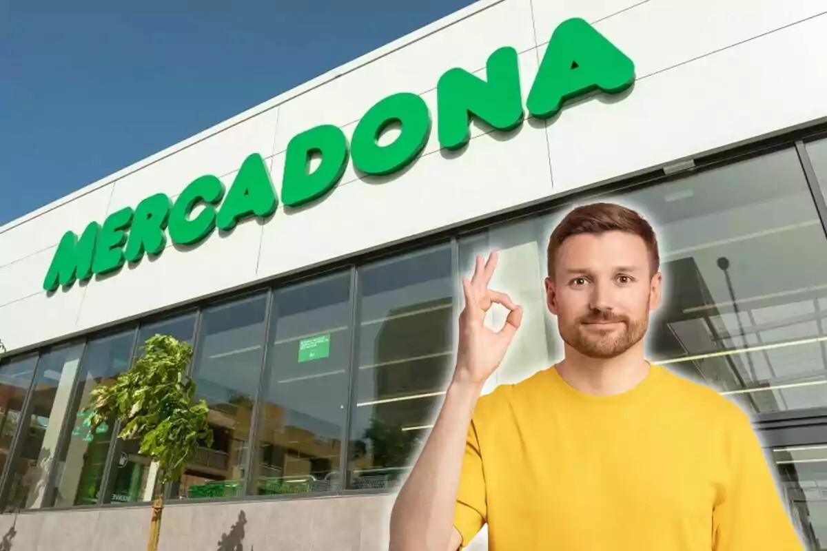 Un home amb samarreta groga fa un gest de “OK” davant d'una botiga de Mercadona.