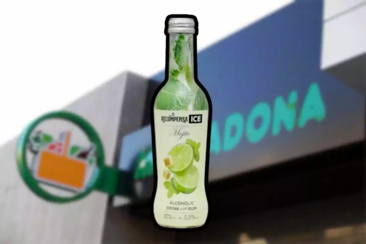 Ampolla de beguda alcohòlica sabor mojito davant d'un cartell de supermercat. Ampolla de beguda alcohòlica sabor mojito davant d'un cartell de supermercat.