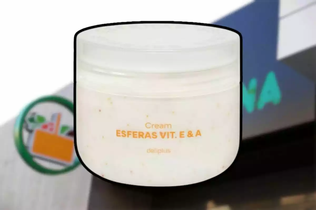 Envàs de crema Deliplus Esferes Vitamina E i A davant d’una botiga Mercadona desenfocada Envàs de crema Deliplus Esferes Vitamina E i A davant d’una botiga Mercadona desenfocada