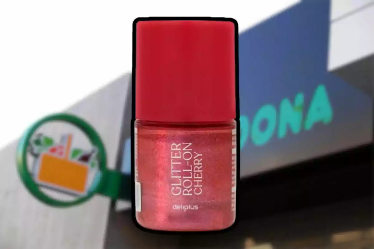 Cherry-colored glitter roll-on container from the Deliplus brand with a red cap, in front of a blurred Mercadona store. Cherry-colored glitter roll-on container from the Deliplus brand with a red cap, in front of a blurred Mercadona store.