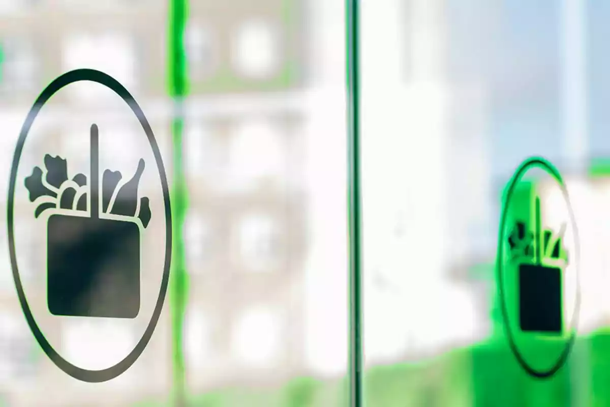 A logo of a shopping bag with vegetables on a glass window. A logo of a shopping bag with vegetables on a glass window.