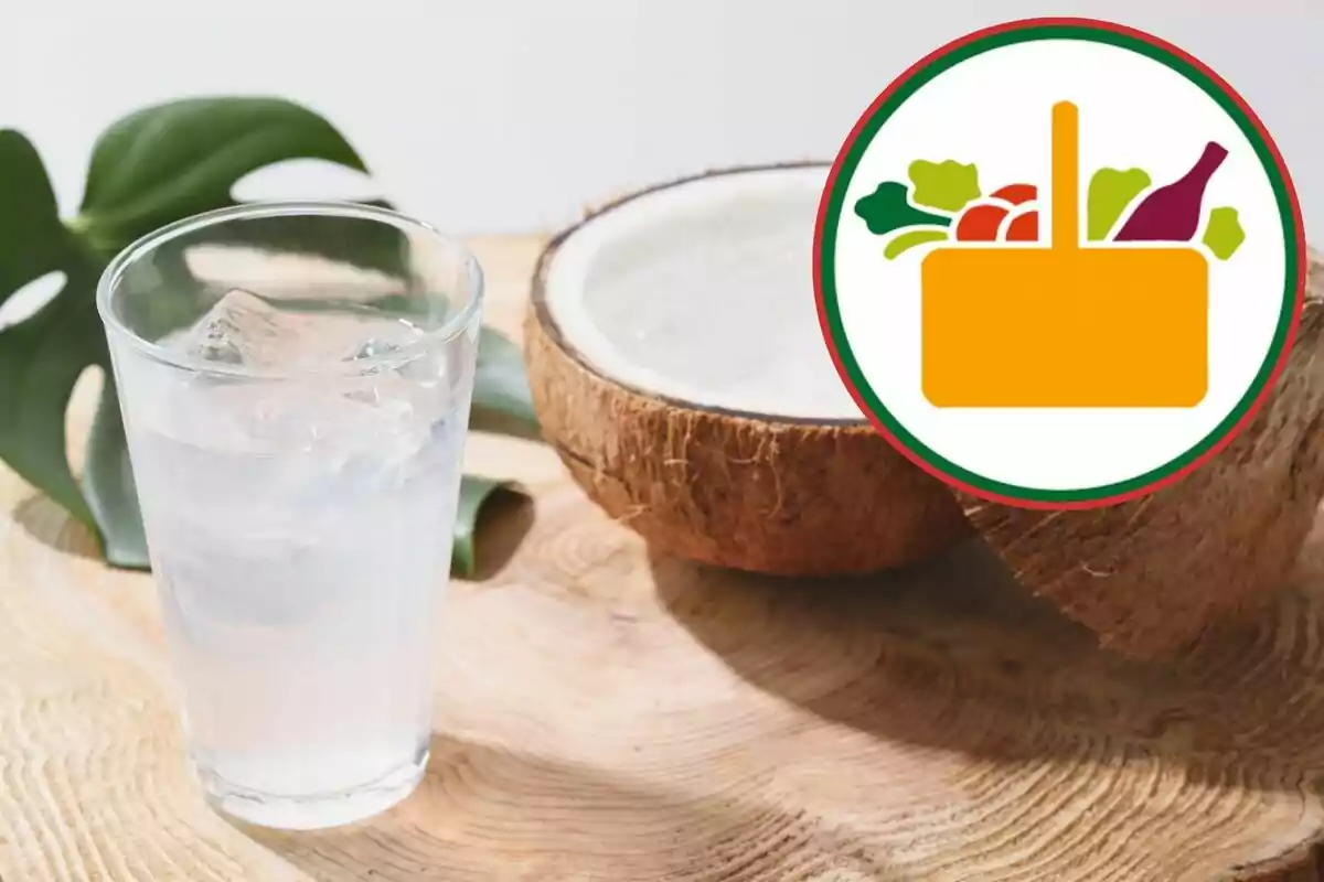 Got d’aigua de coco amb gel al costat d’un coco partit sobre una taula de fusta i una icona de cistell de supermercat Got d’aigua de coco amb gel al costat d’un coco partit sobre una taula de fusta i una icona de cistell de supermercat